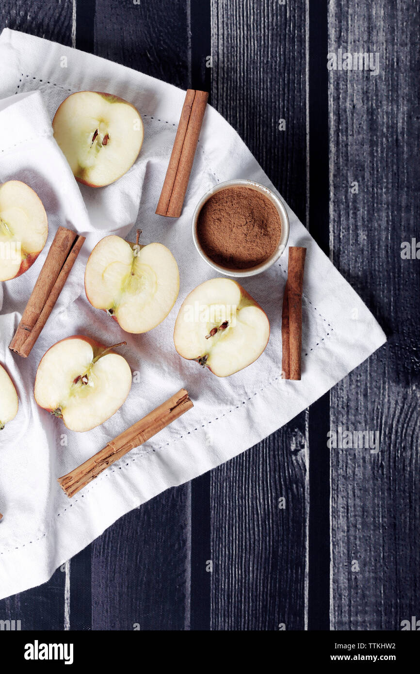 Close-up de tranches de pomme avec cinnamons sur table en bois plus de textiles Banque D'Images