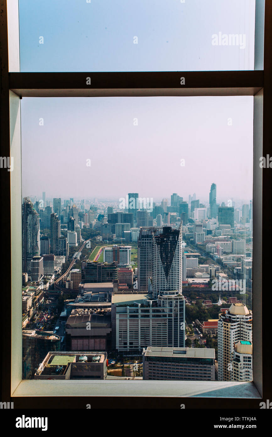 Skyscrapers in city contre ciel vu par la fenêtre Banque D'Images