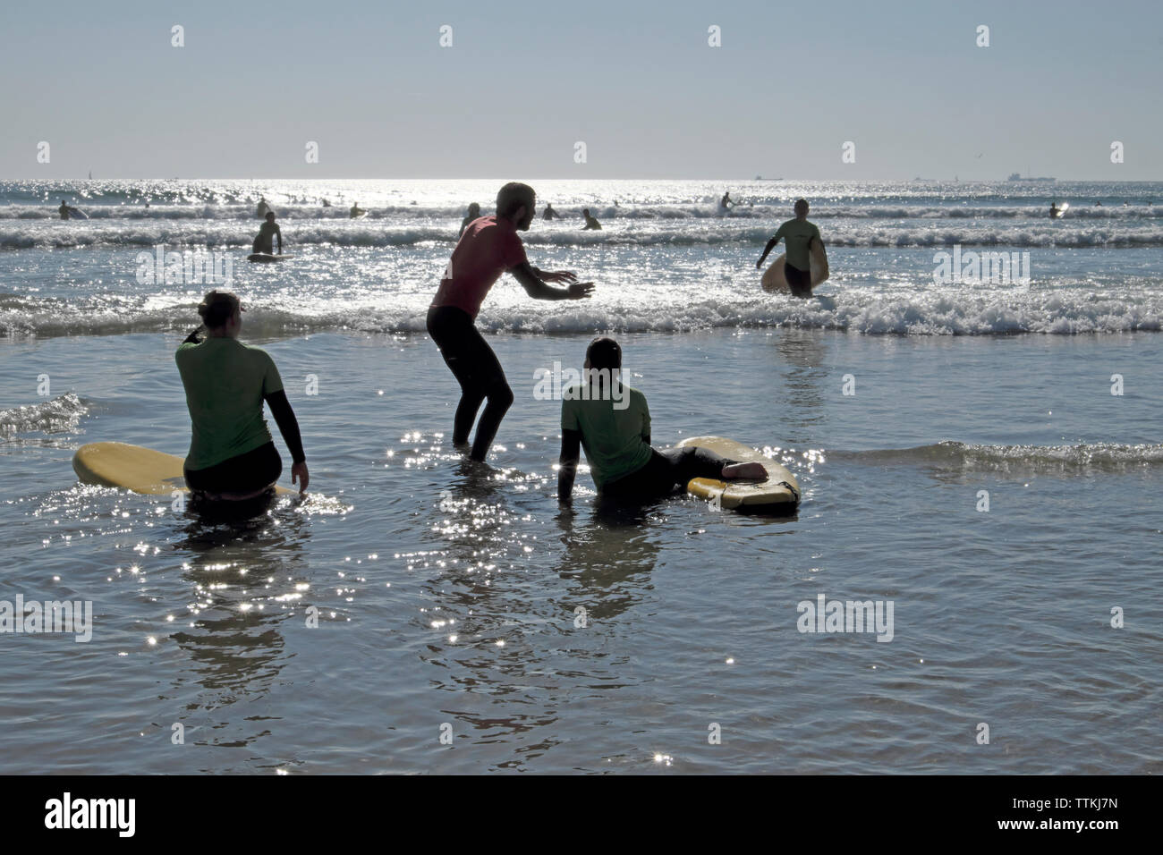 Un instructeur de surf les jeunes femmes montre comment apprendre à surfer à l'équilibre sur une planche de surf dans l'eau à Matosinhos Porto Portugal Europe UE KATHY DEWITT Banque D'Images