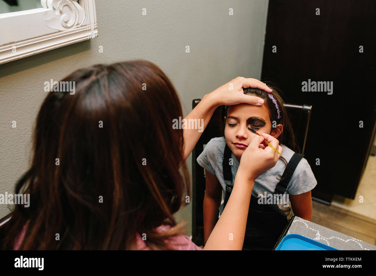 Woman applying make-up sur le visage de fille à la maison Banque D'Images