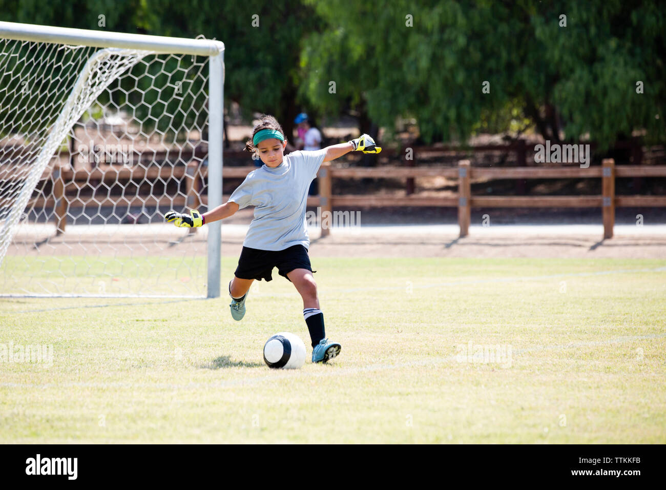 Girl playing soccer in playground Banque D'Images