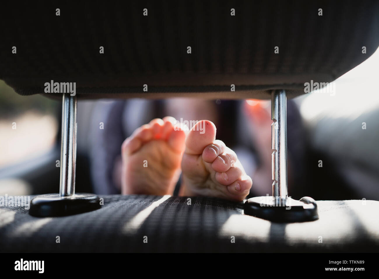 Close-up of girl's pieds posés sur le siège du véhicule en location Banque D'Images