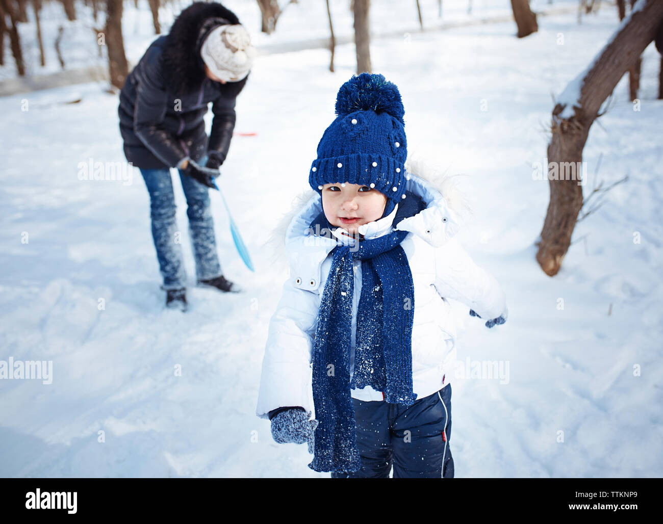 Portrait of cute fille avec la mère sur champ neigeux Banque D'Images