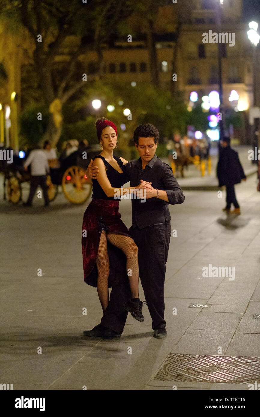 Un couple danse dans les rues de Sevilla Banque D'Images