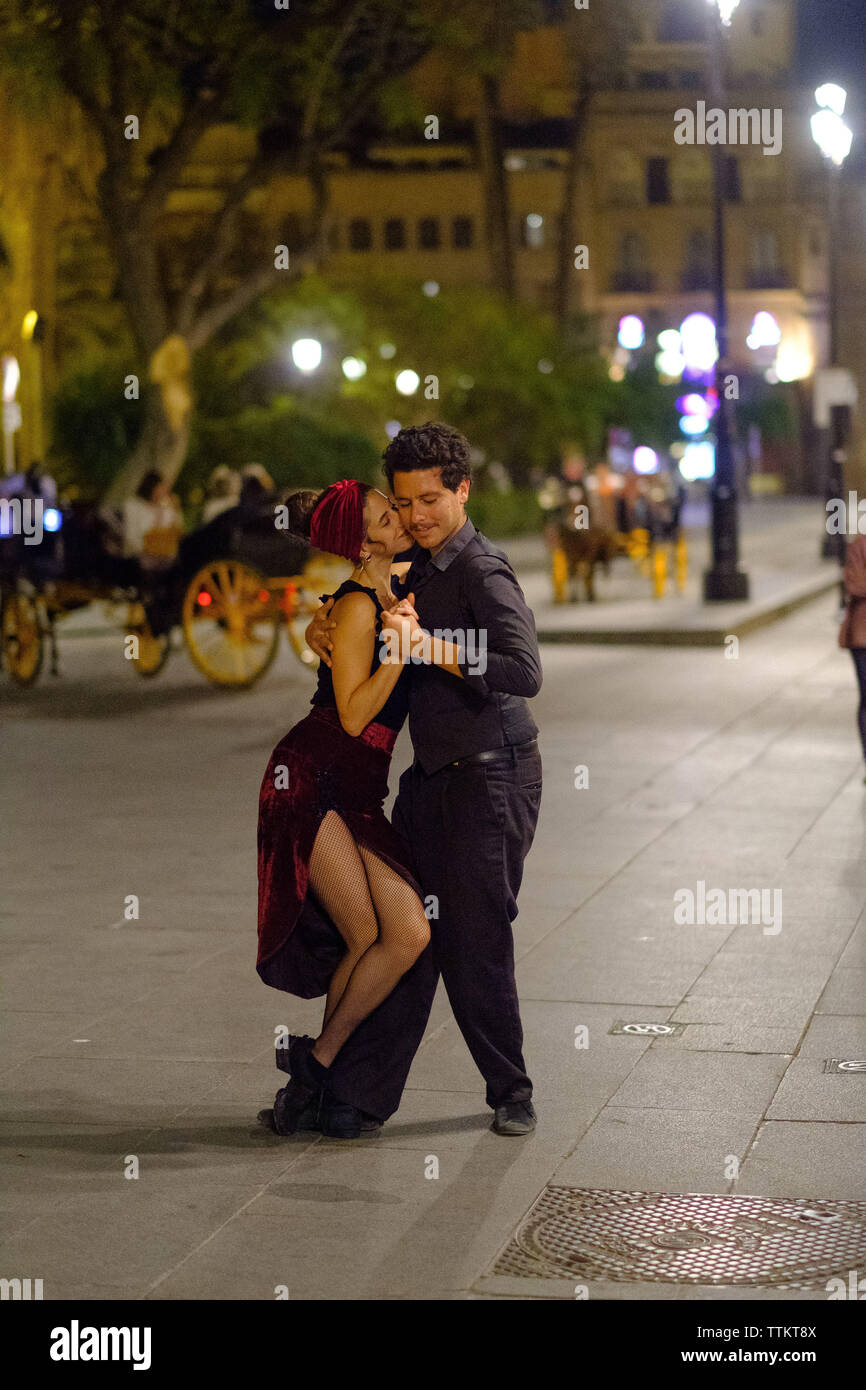 Un couple danse dans les rues de Sevilla Banque D'Images