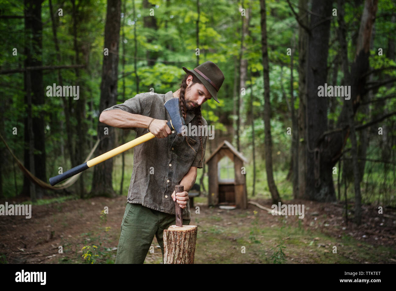 L'homme coupe de bois avec un marteau en forêt Banque D'Images