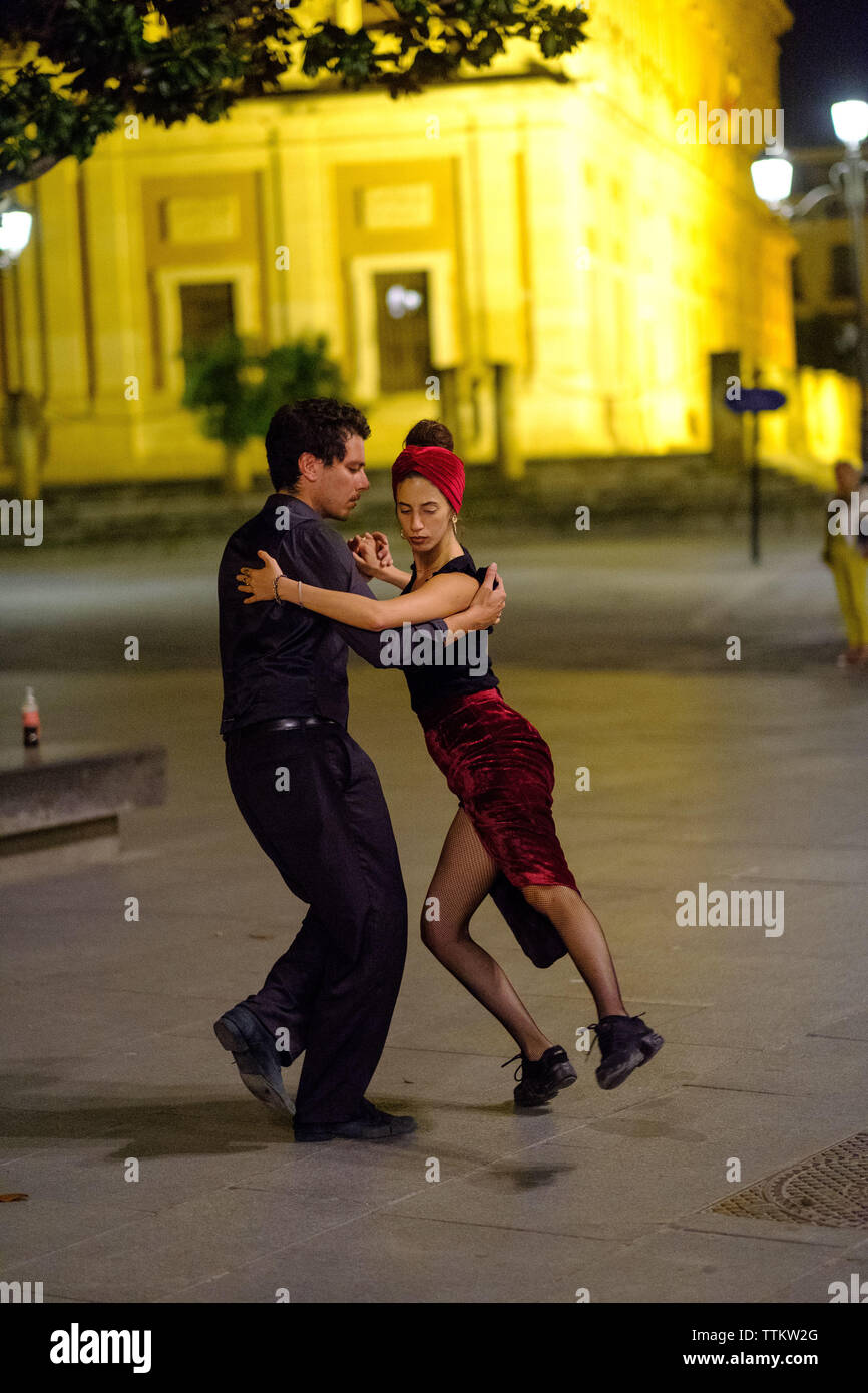Un couple danse dans les rues de Sevilla Banque D'Images