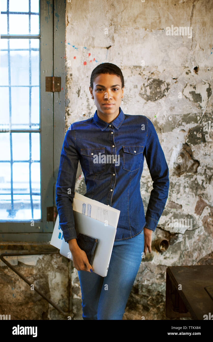 Confiant Fashion designer holding documents tout en se tenant à l'ancien atelier Banque D'Images