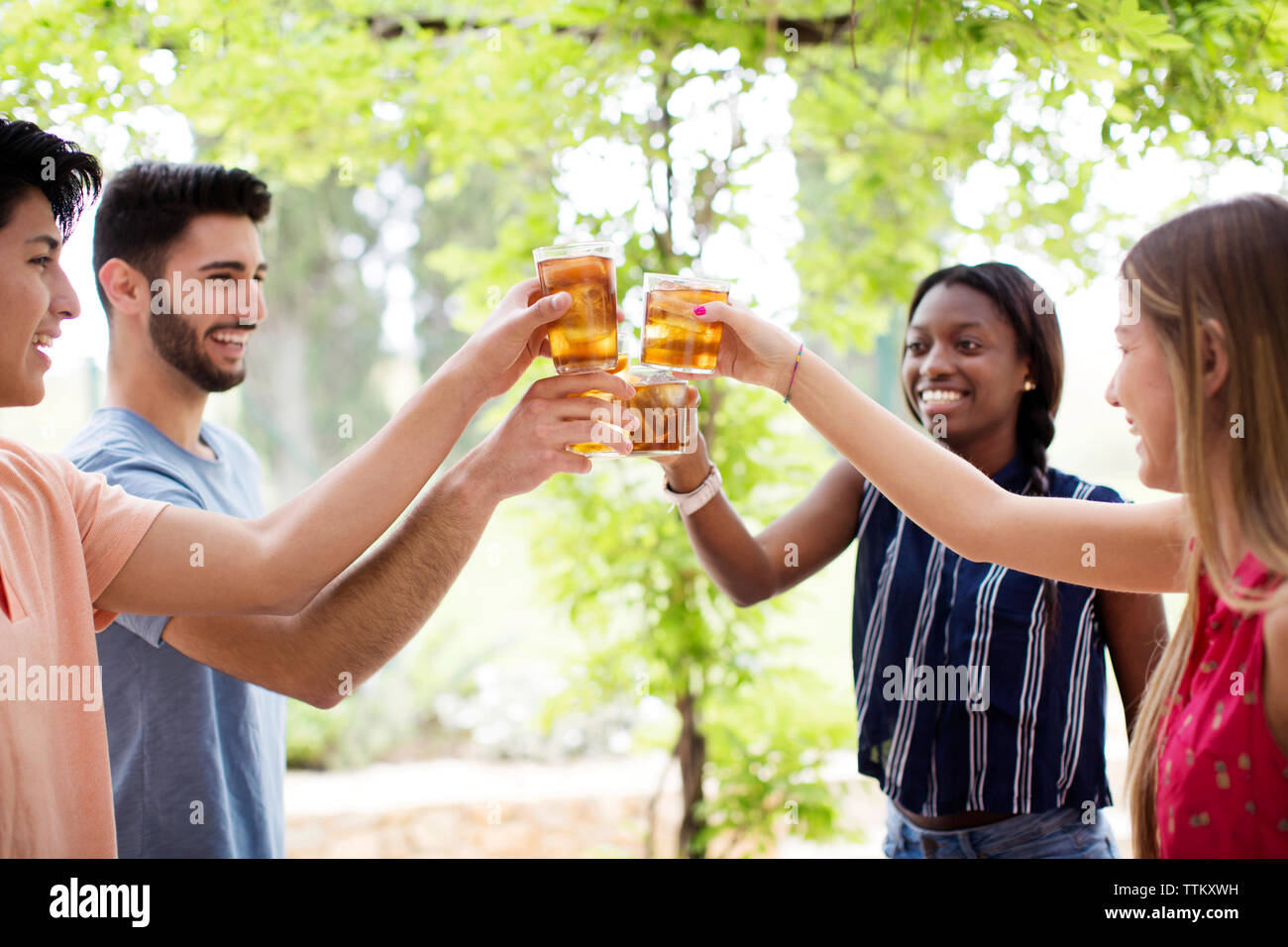 Professionnels multi-ethnic friends toasting at yard lunettes thé glacé Banque D'Images