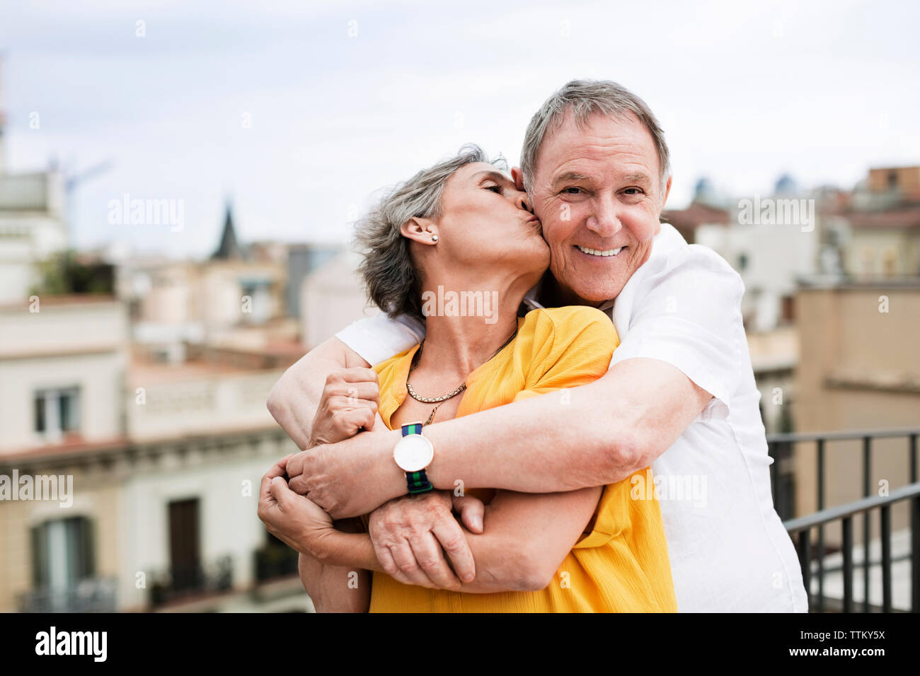 Mature romantique woman kissing man on terrace Banque D'Images