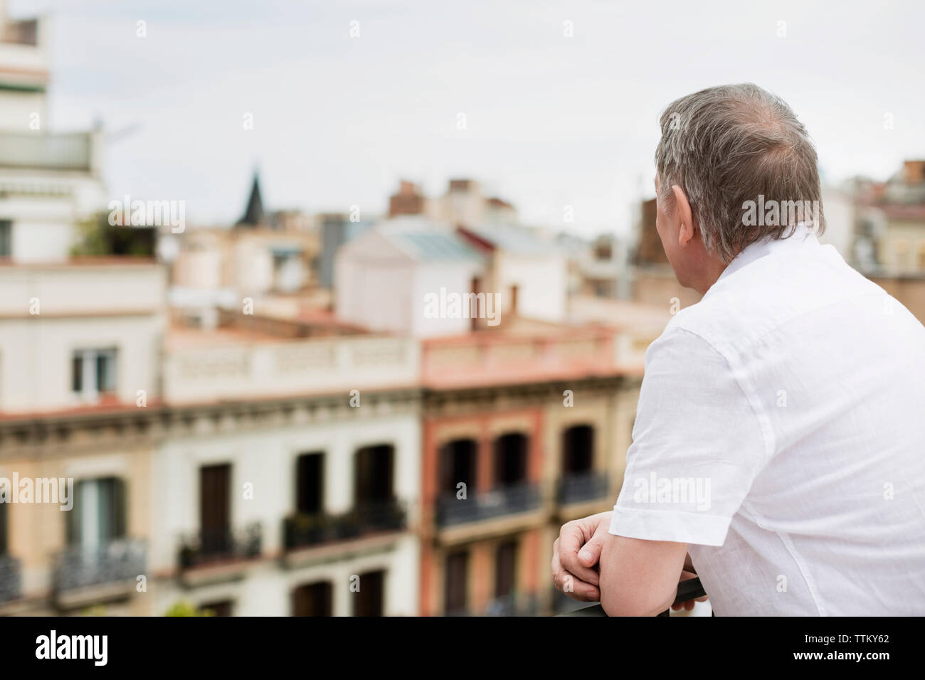 Vue latérale du senior man looking at vue sur la ville à partir de la terrasse Banque D'Images