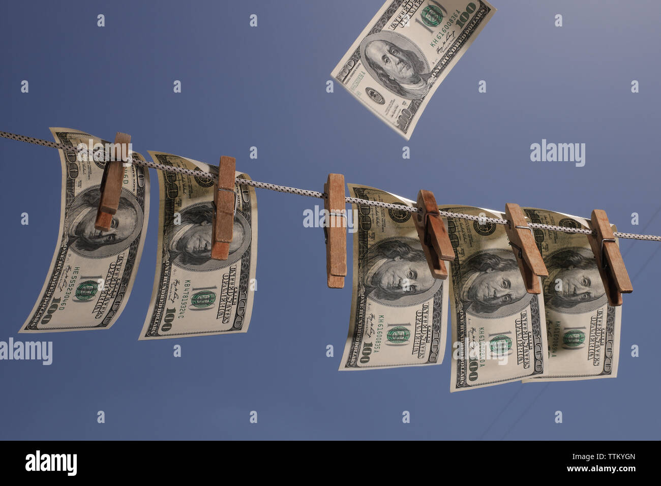 Argent accroché sur une corde avec des pinces à linge en bois ancien. Le symbole de placements à l'étranger, les crimes financiers et le blanchiment d'argent. Banque D'Images