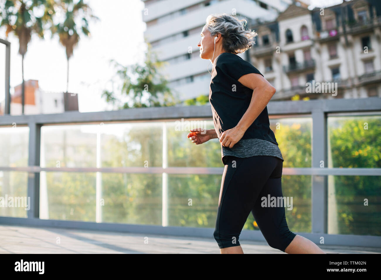 Vue latérale du woman jogging on bridge Banque D'Images