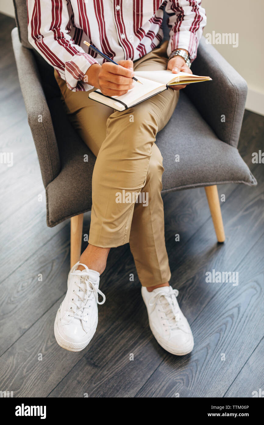 High angle view of woman diary while sitting on chair at office Banque D'Images