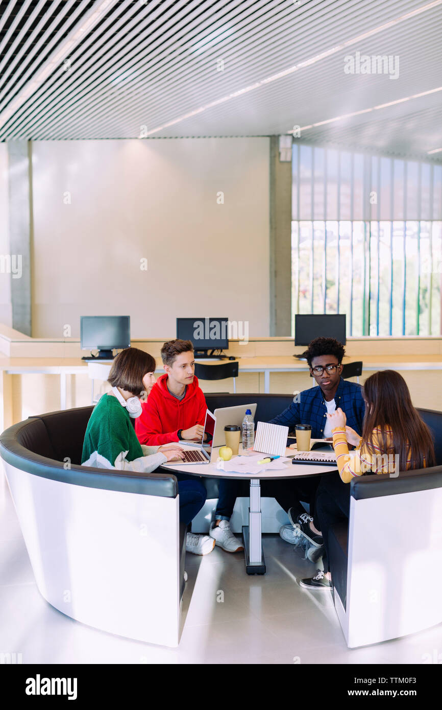 Les amis de discuter tout en étudiant dans la bibliothèque Banque D'Images