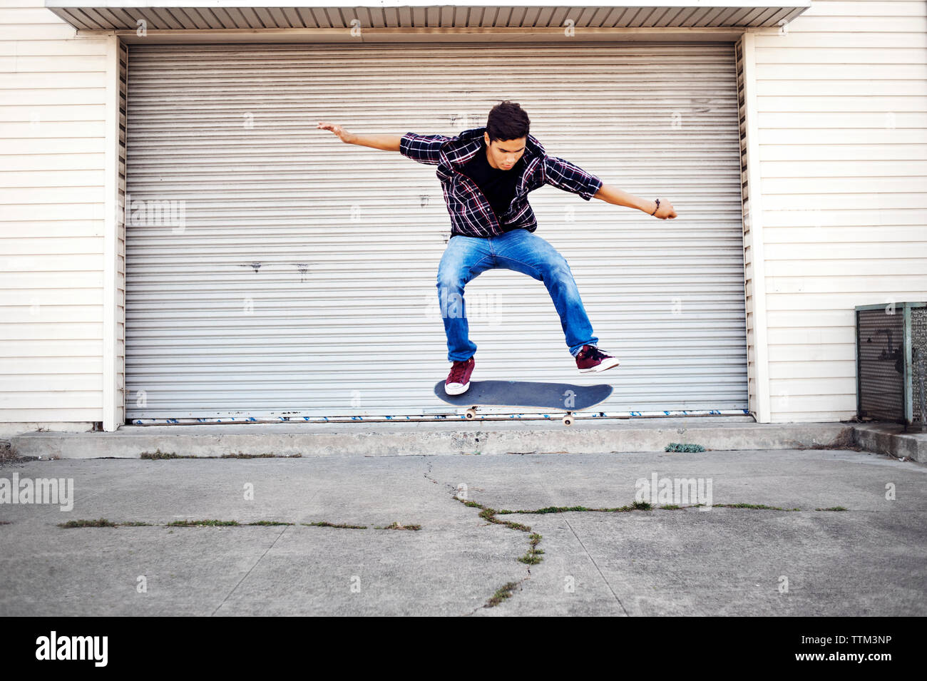 Man performing stunt contre magasin fermé Banque D'Images
