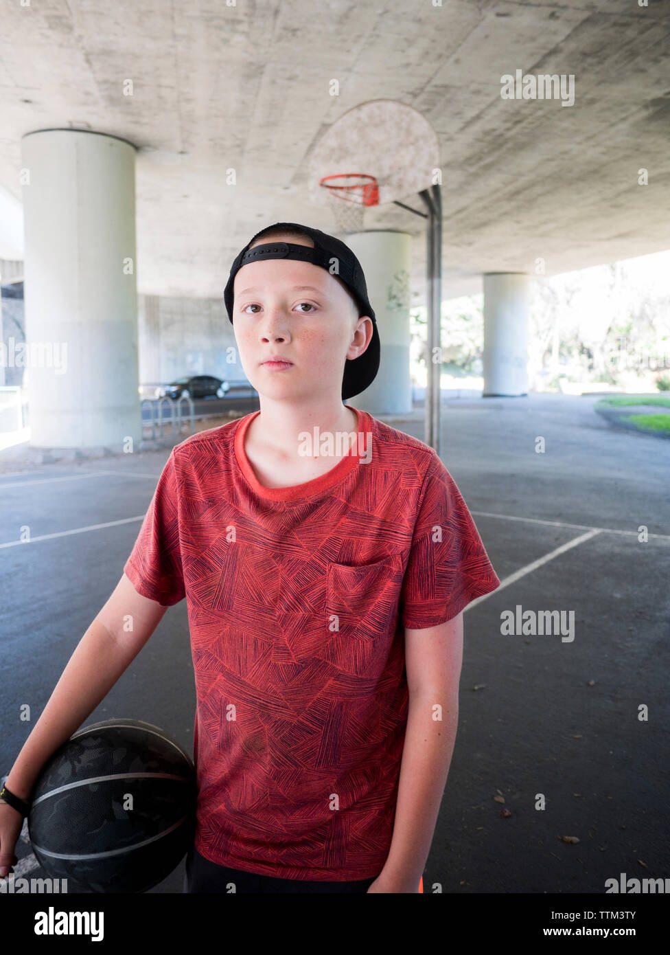 Portrait of boy holding ball au basket-ball Banque D'Images