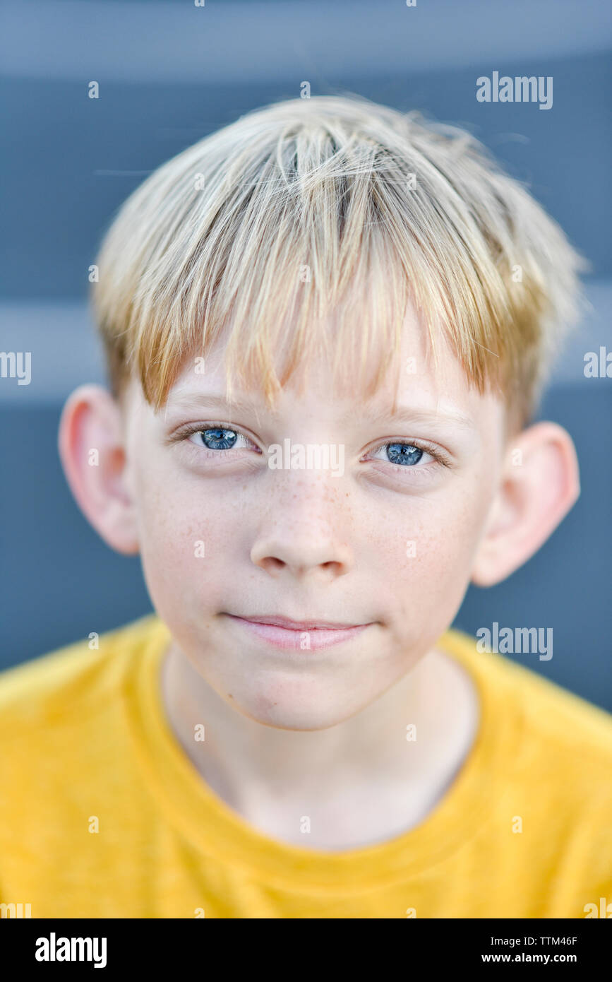 Close-up portrait of boy aux cheveux blonds debout sur road Banque D'Images