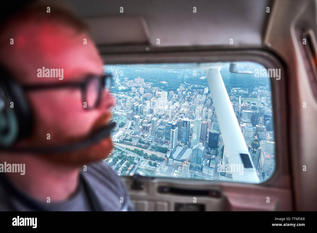 Pilote aux commandes avion sur cityscape Banque D'Images