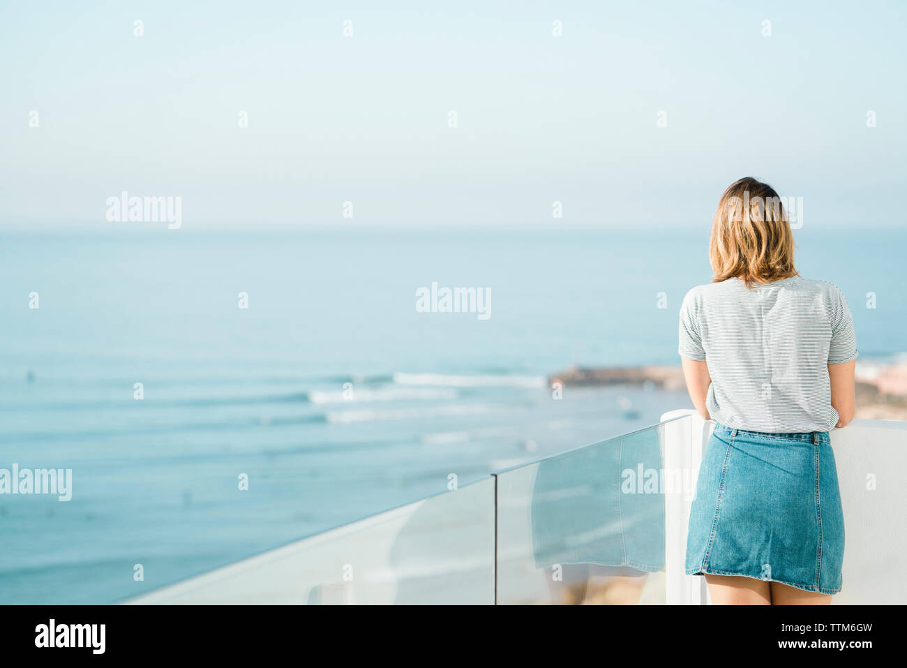 Woman looking at view debout contre la mer et le ciel en balcon Banque D'Images