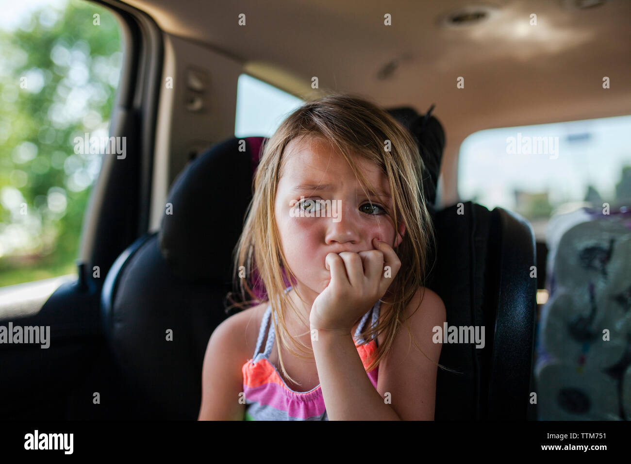 Upset girl looking away while sitting in car Banque D'Images