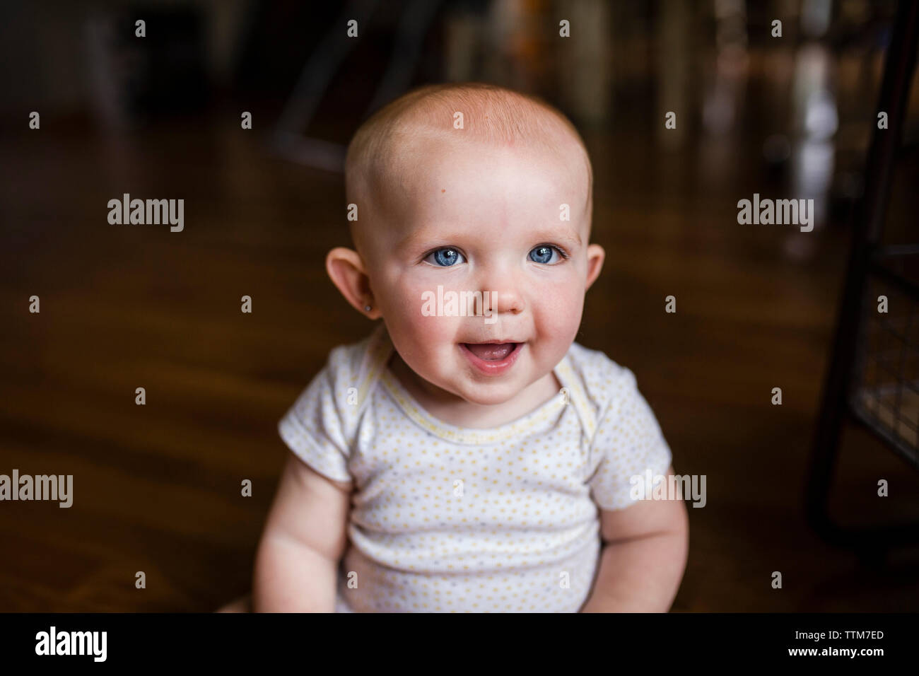 Portrait of happy baby girl sitting at home Banque D'Images