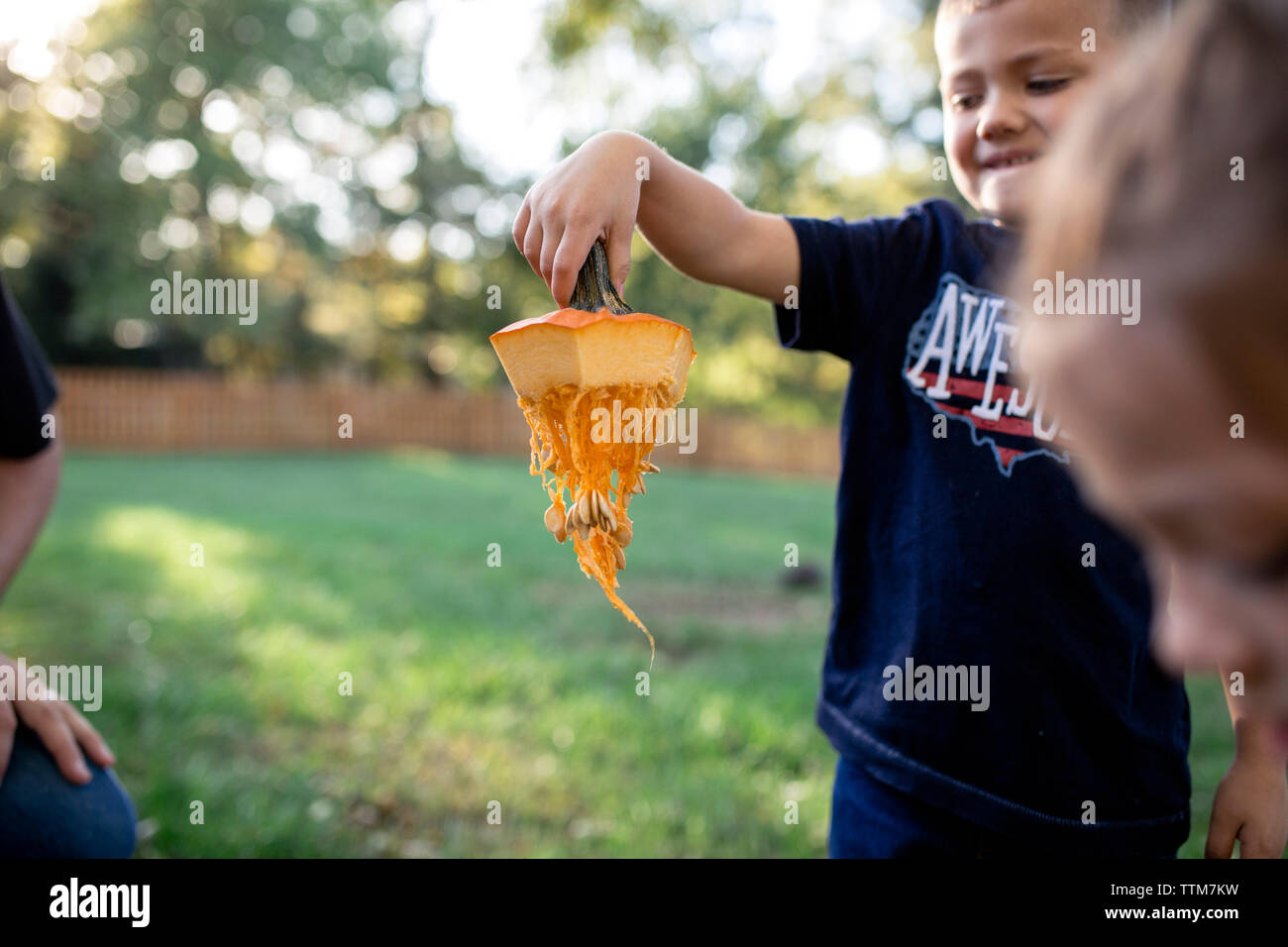 Boy holding Tige de citrouille tout en se tenant debout dans une cour à l'Halloween Banque D'Images