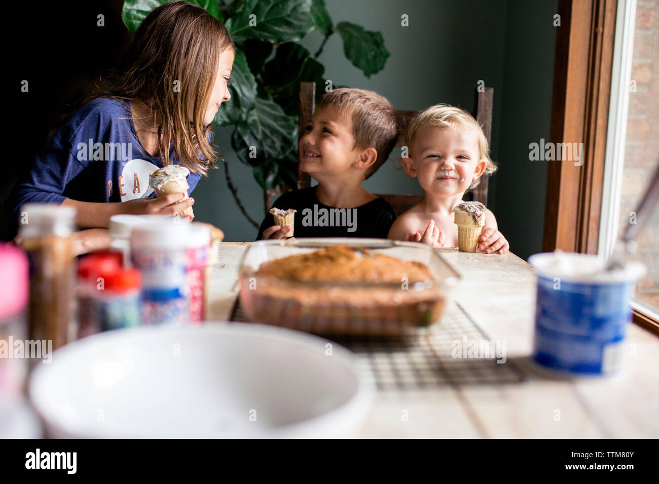 Trois enfants bénéficiant des friandises d'être idiot Banque D'Images