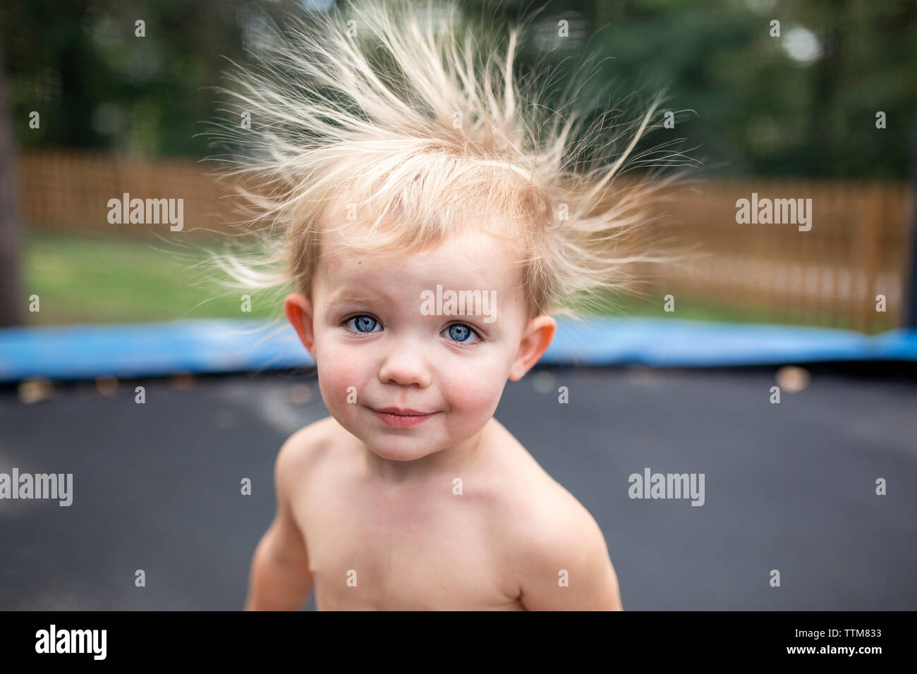 Bébé fille sur trampoline avec wild cheveux statique Banque D'Images