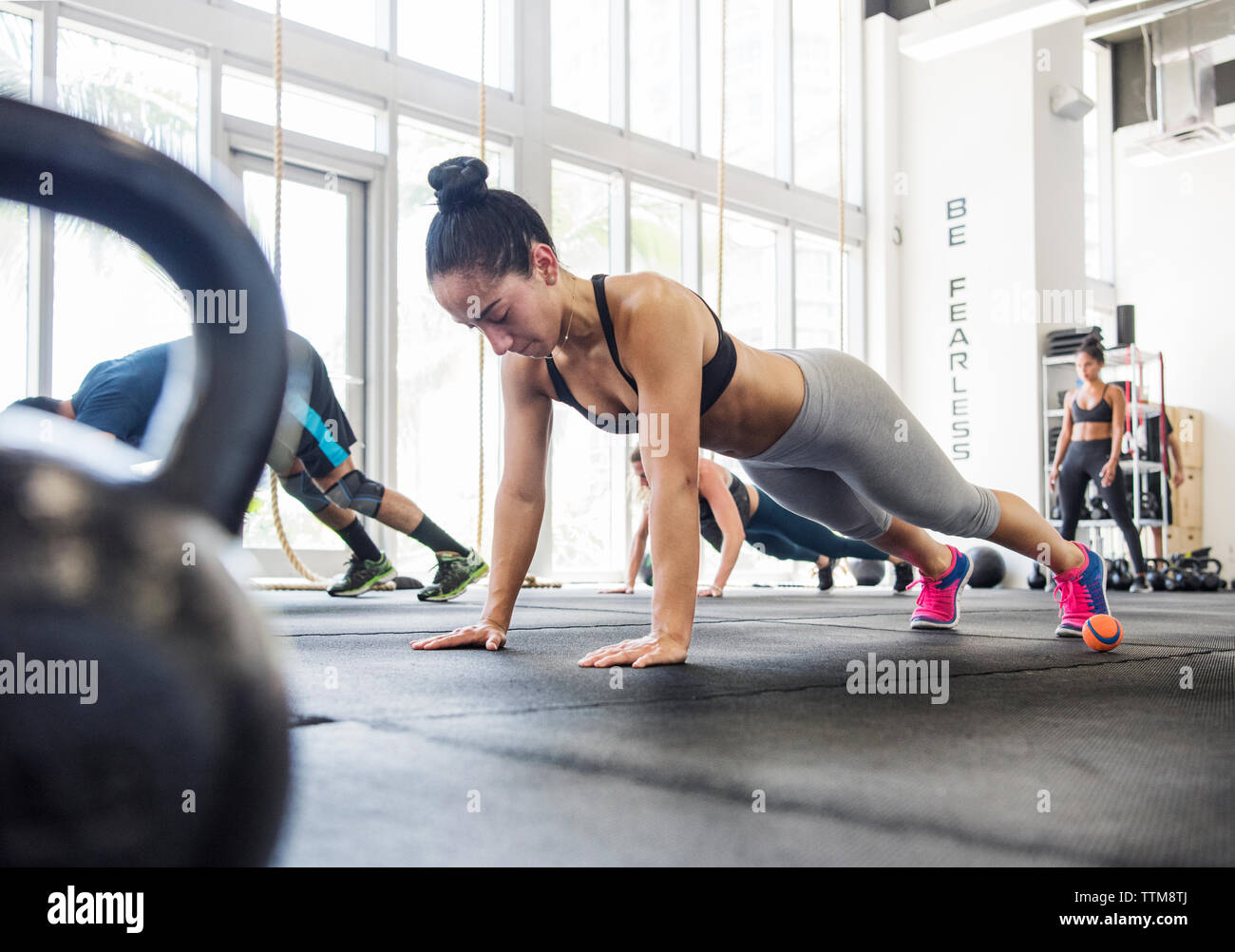 Niveau de la surface d'athlètes faisant push-ups en gym crossfit Banque D'Images