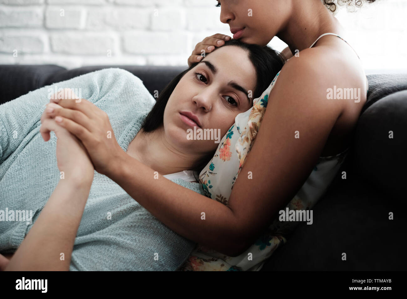 Portrait of woman relaxing on la poitrine de petite amie à la maison Banque D'Images