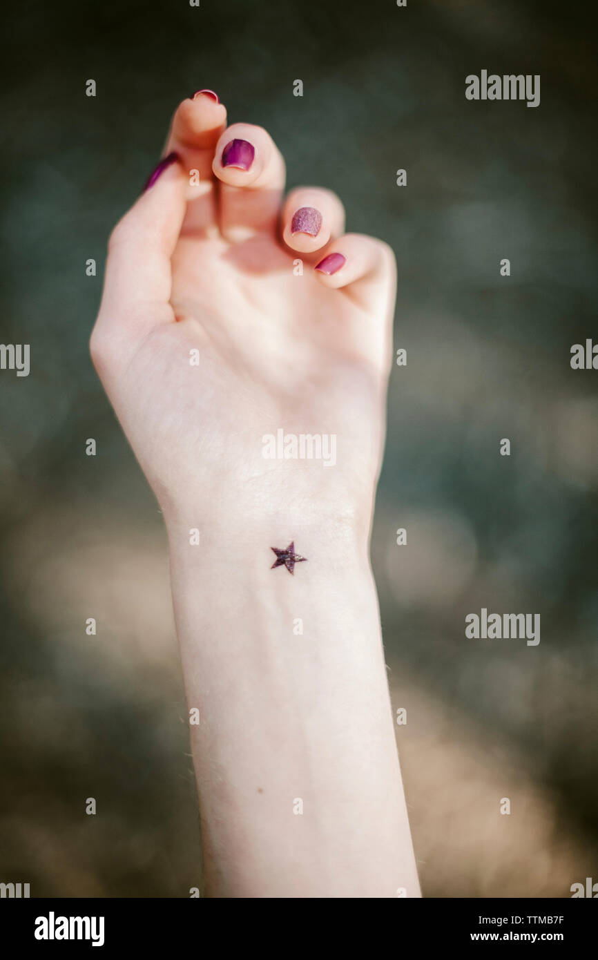 Close-up of star shape tatouage sur la main de la jeune femme Banque D'Images