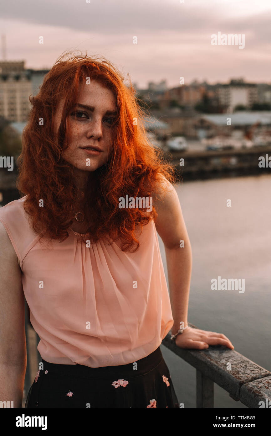 Portrait de jeune femme aux cheveux rouges l'article by railing on bridge Banque D'Images