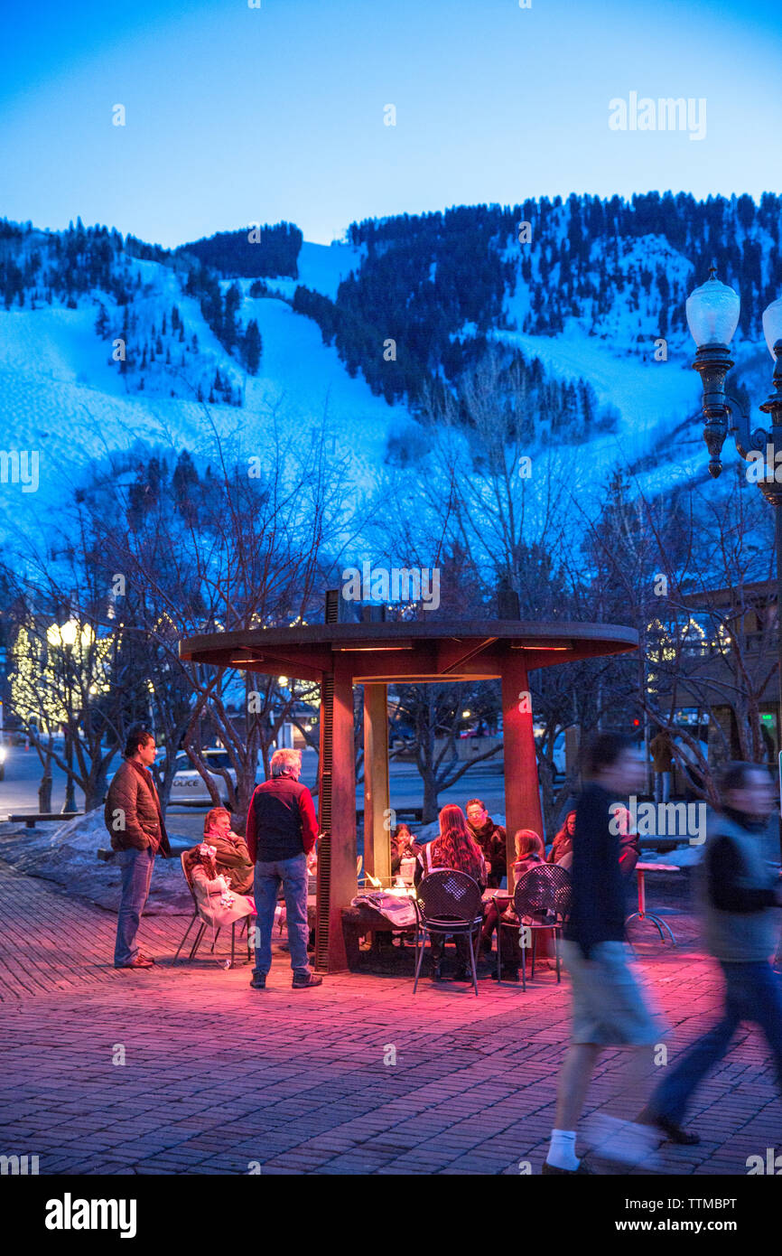 USA, Colorado, tremble, les gens se réchauffer au coin du feu dans le m2 au centre-ville d'Aspen au crépuscule Banque D'Images