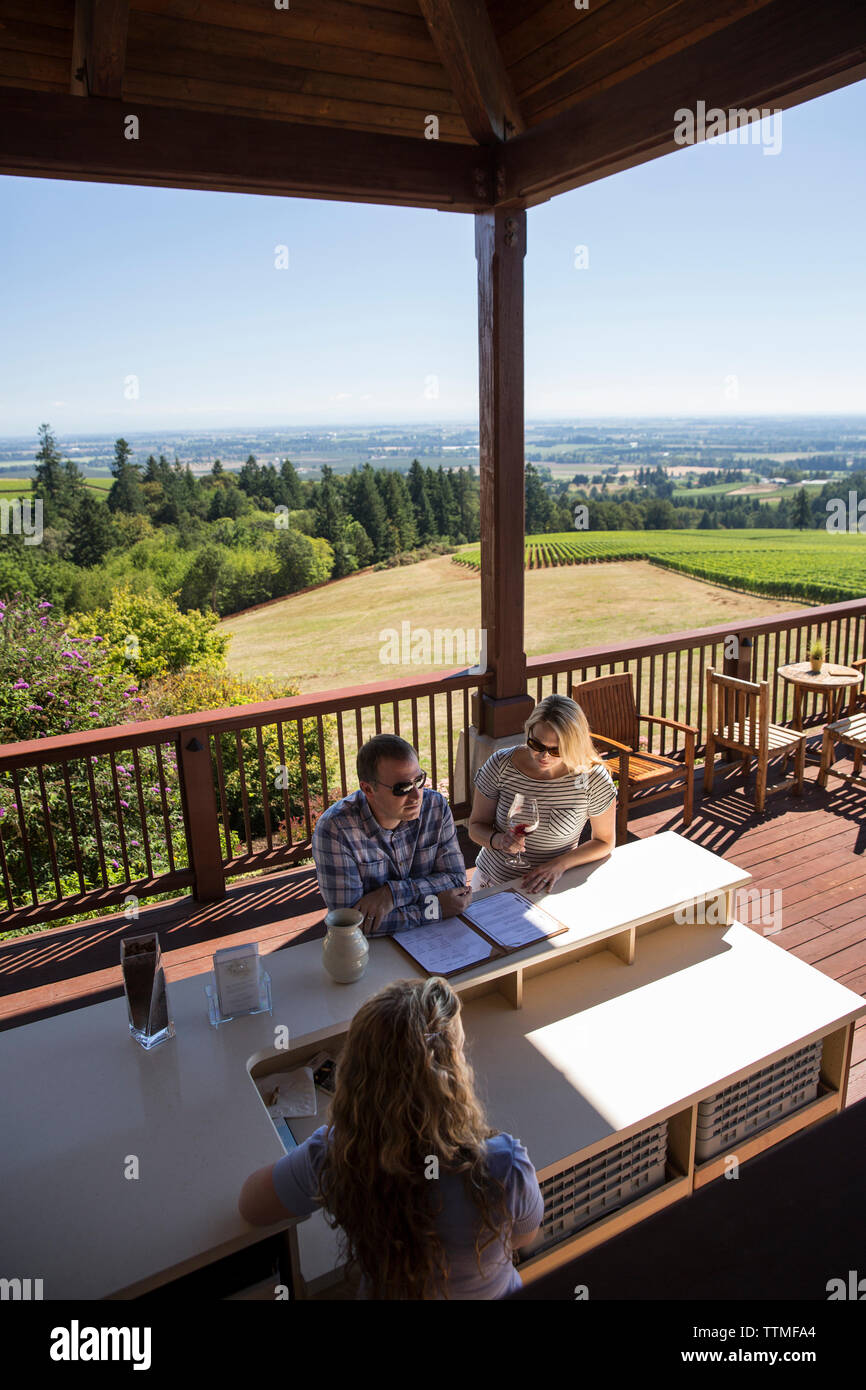 USA, Ohio, Willamette Valley, un couple goûte vin sur un patio extérieur au vignoble Domaine Drouhin, Dundee Banque D'Images