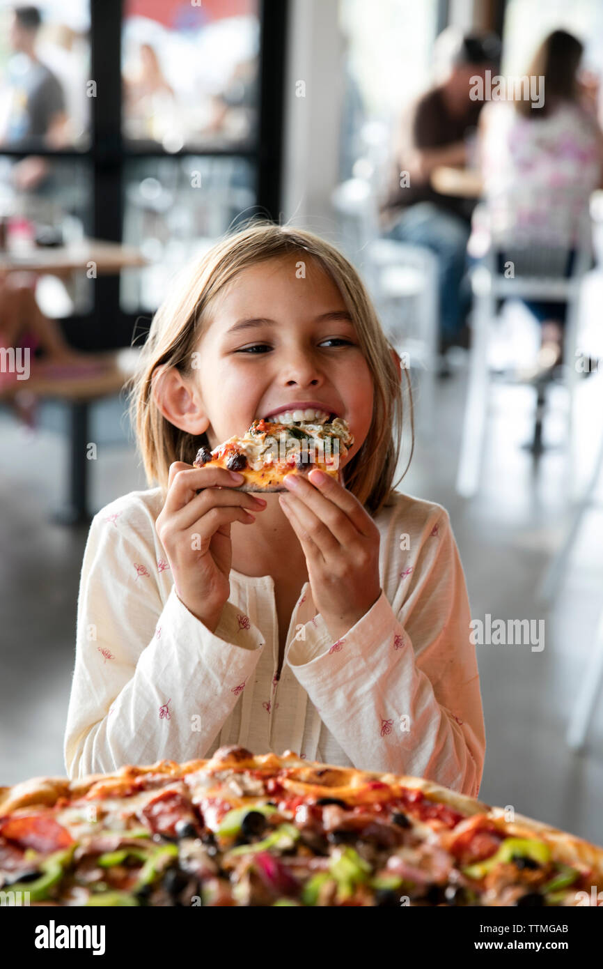USA (Oregon, Bend, Pacific Pizza et Brew, girl eating pizza Banque D'Images