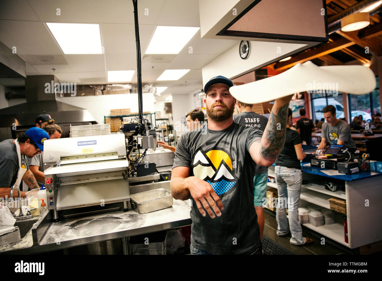 USA (Oregon, Bend, Pacific Pizza et Brew, chef de pizza tossing pâte Banque D'Images