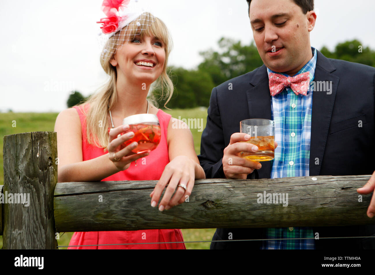 USA, New York, Nashville, course d'Iroquois, un jeune homme et femme par une clôture Moonshine potable Cherry-Basil Blush et Tennessee Whiskey Banque D'Images