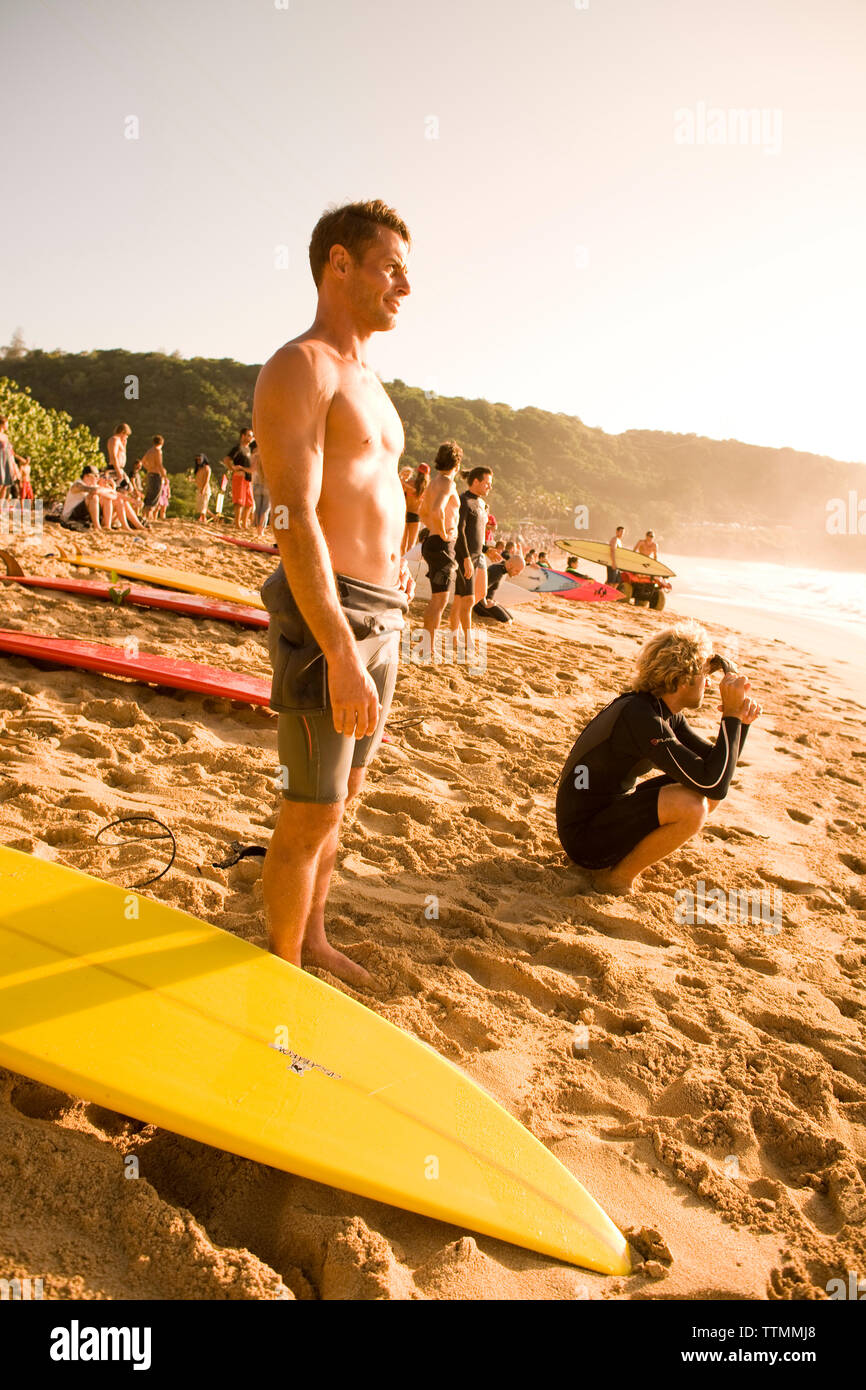 USA, Hawaii, Oahu, surfeurs et foule regarder grand surf à Waimea Bay, North Shore Banque D'Images