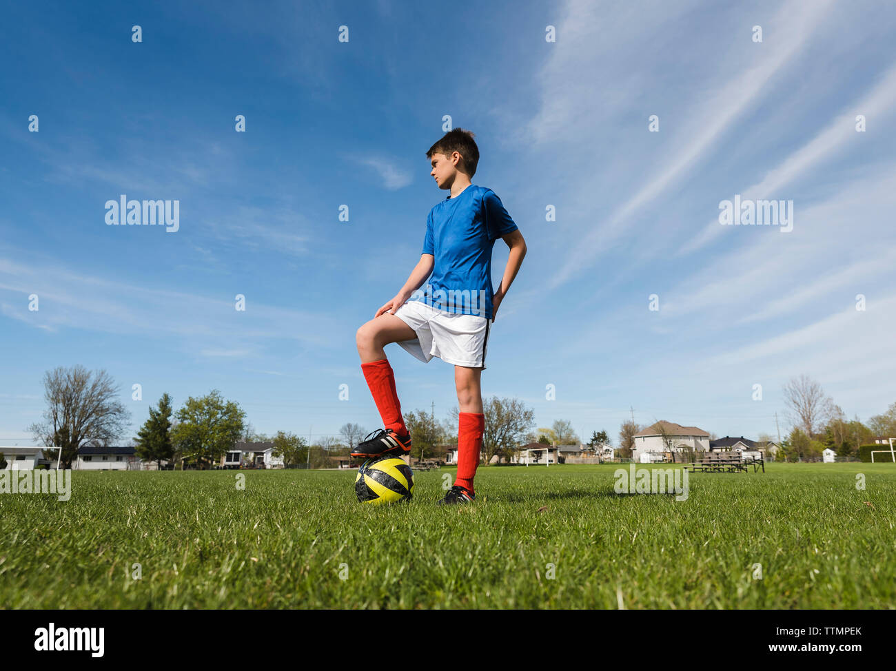 Low angle view of boy with soccer ball debout sur les champs Banque D'Images