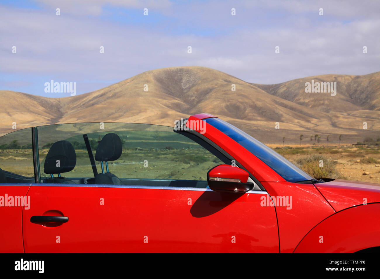 Close up of red cabriolet dans les montagnes sèches paysage désertique avec arrière-plan - Lanzarote, El Cotillo Banque D'Images