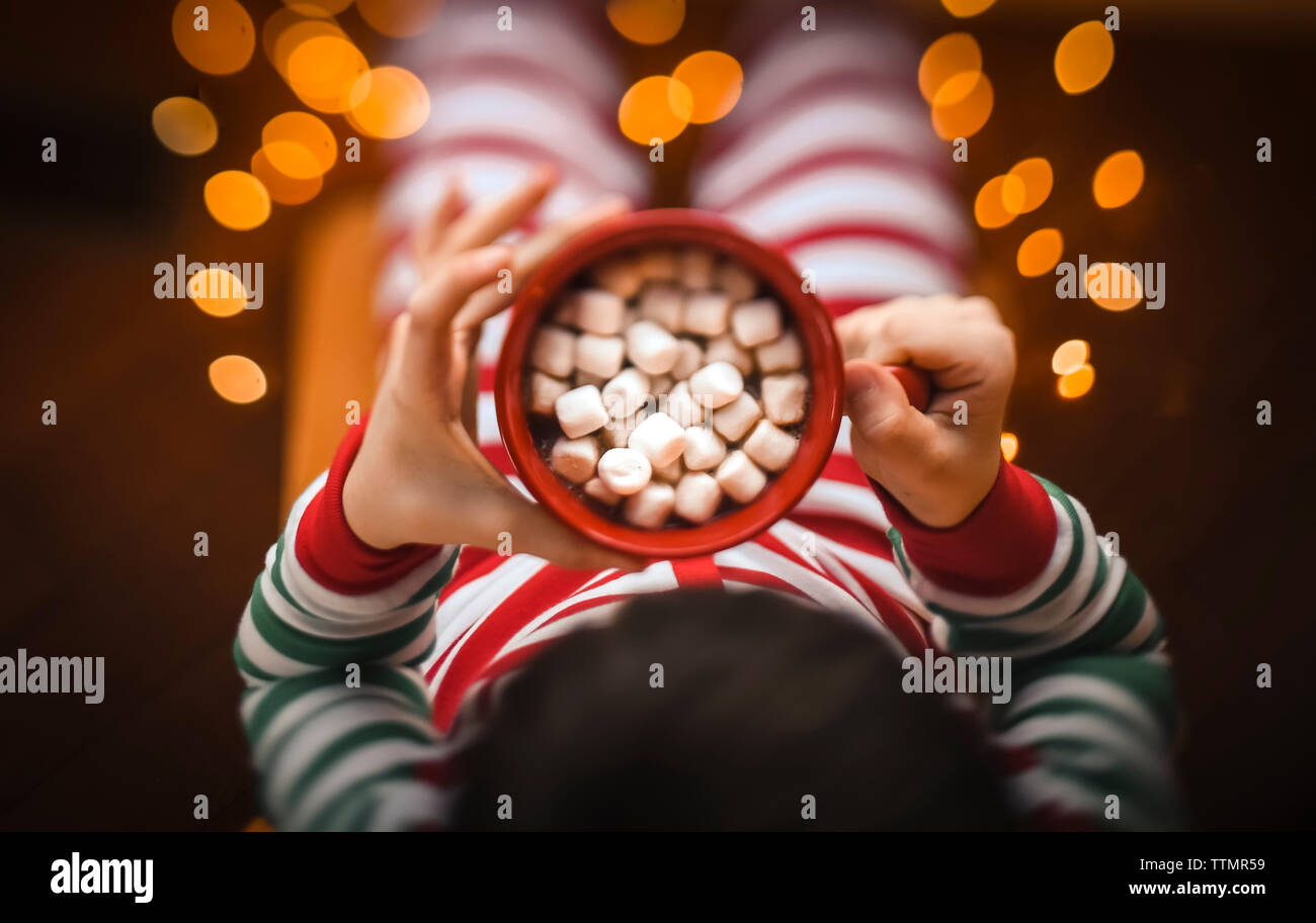 Coup de frais généraux de l'enfant tenant tasse de cacao chaud avec des mashmallows. Banque D'Images