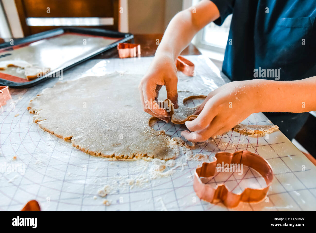 Close up of les mains de l'enfant faire des biscuits avec un emporte-pièce. Banque D'Images