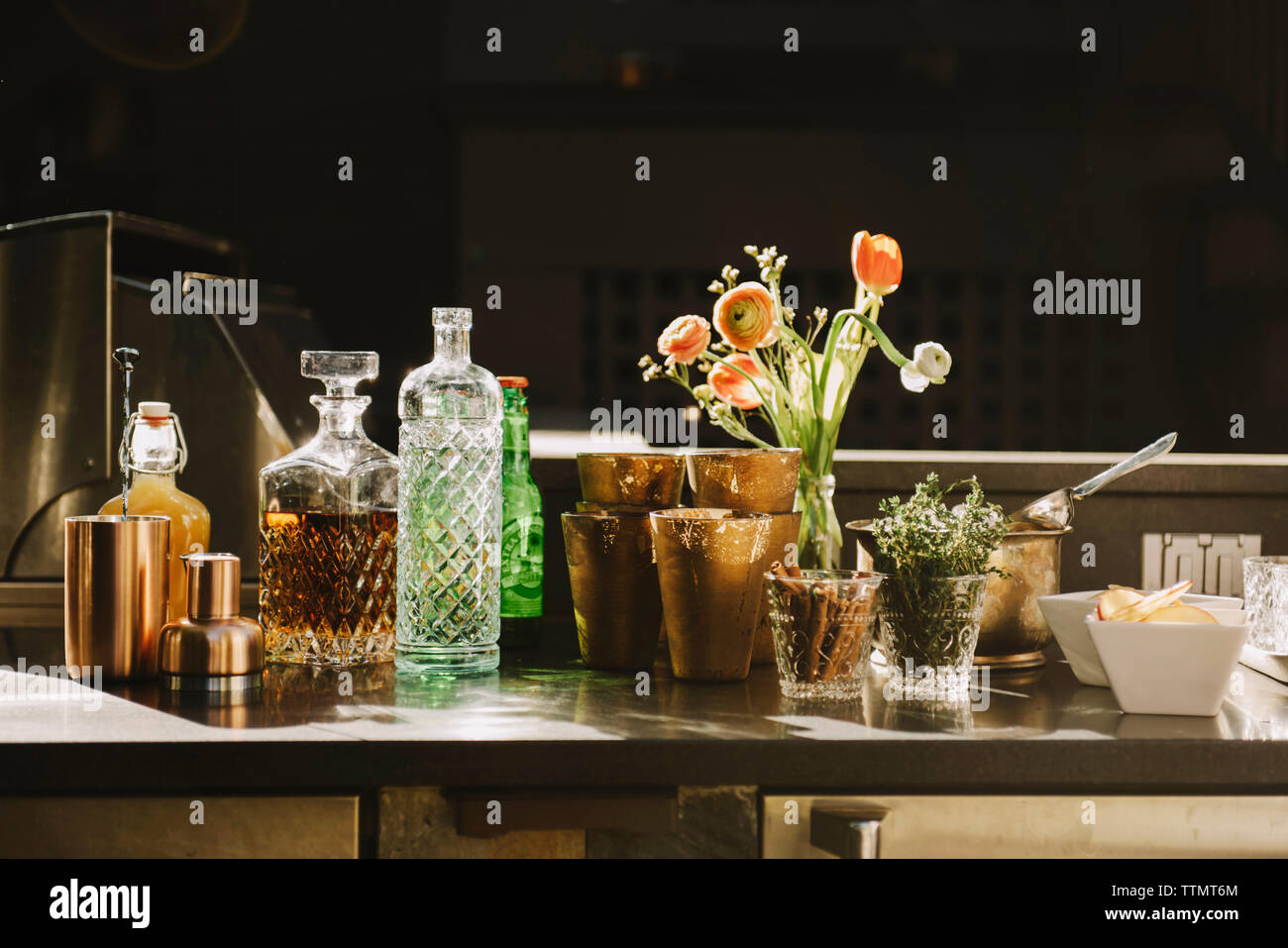 Les bouteilles d'alcool avec vase à fleurs sur table Banque D'Images