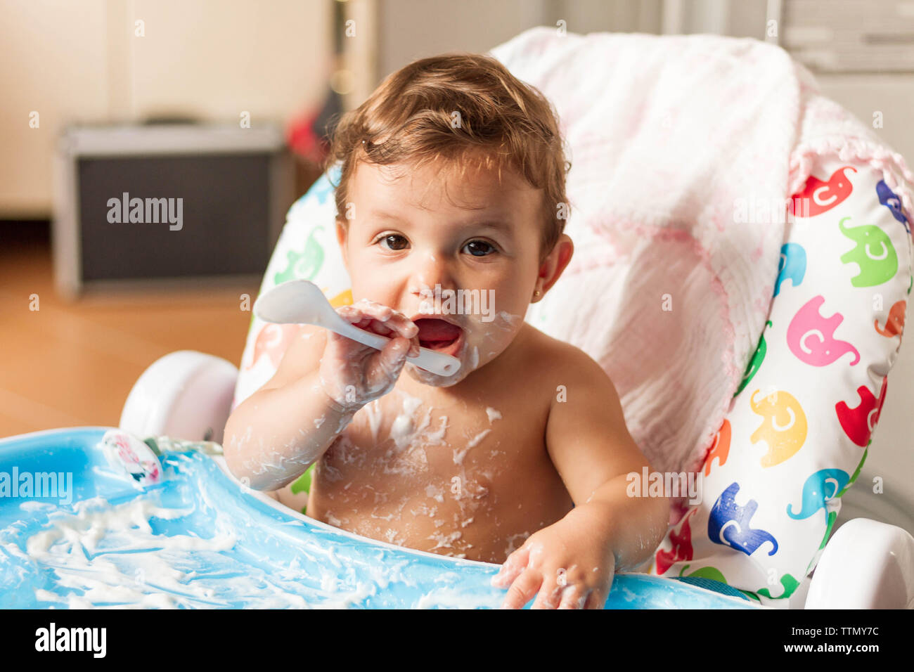 Bébé colorées avec du yaourt parce qu'il mange tout seul Banque D'Images