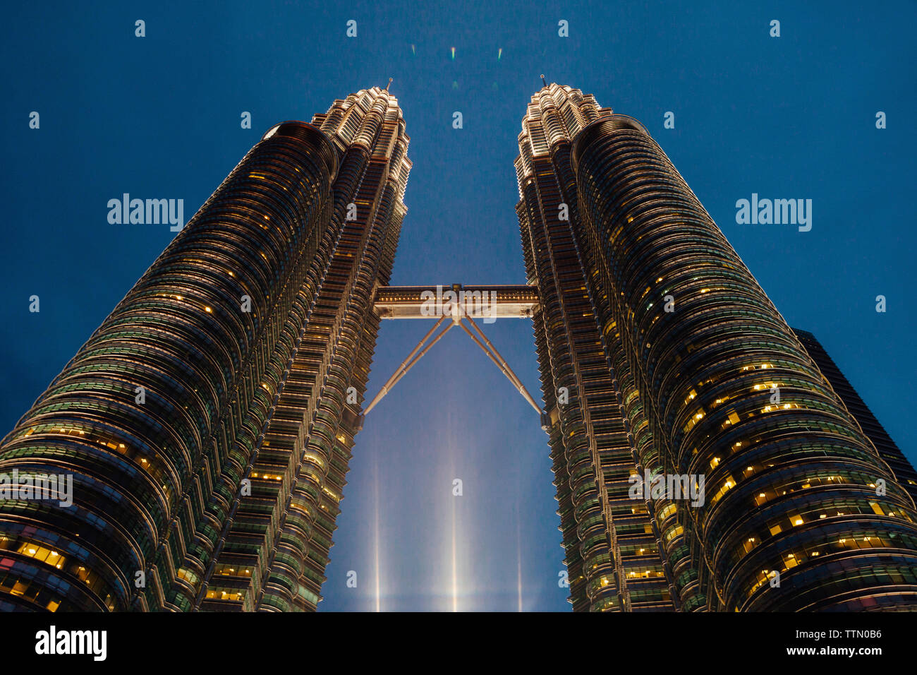 Low angle view of illuminated Petronas Towers contre le ciel de nuit Banque D'Images