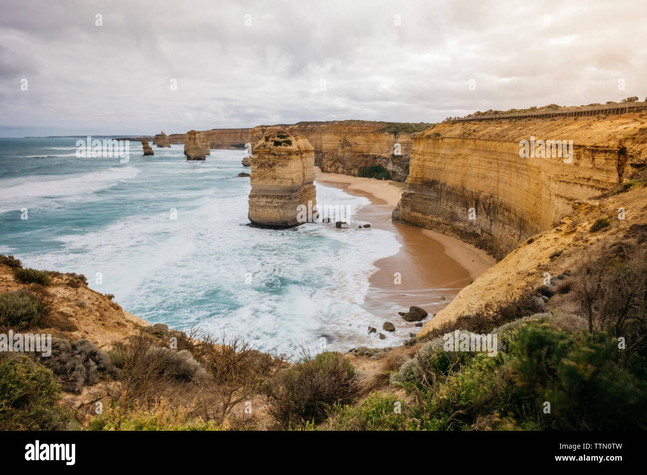 Vue panoramique des formations rocheuses par mer contre ciel nuageux Banque D'Images