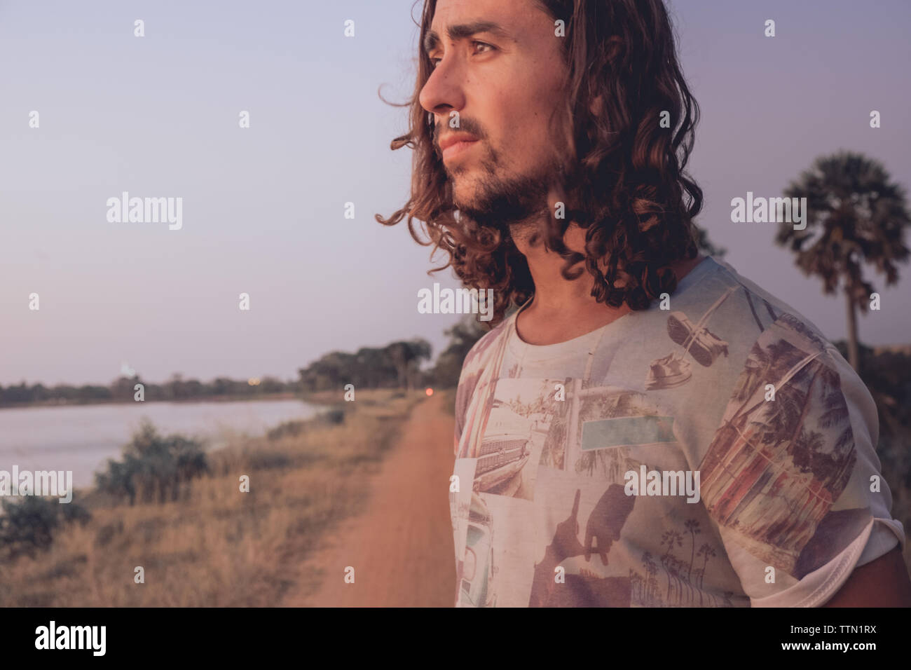 Portrait d'un homme regardant le coucher du soleil outdoor Banque D'Images