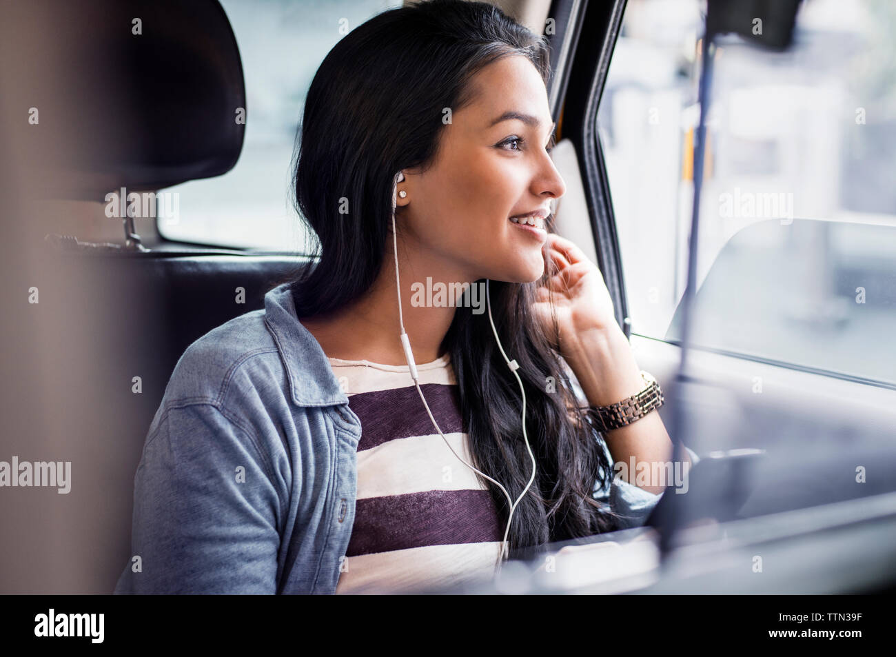 Young woman listening to music in taxi Banque D'Images