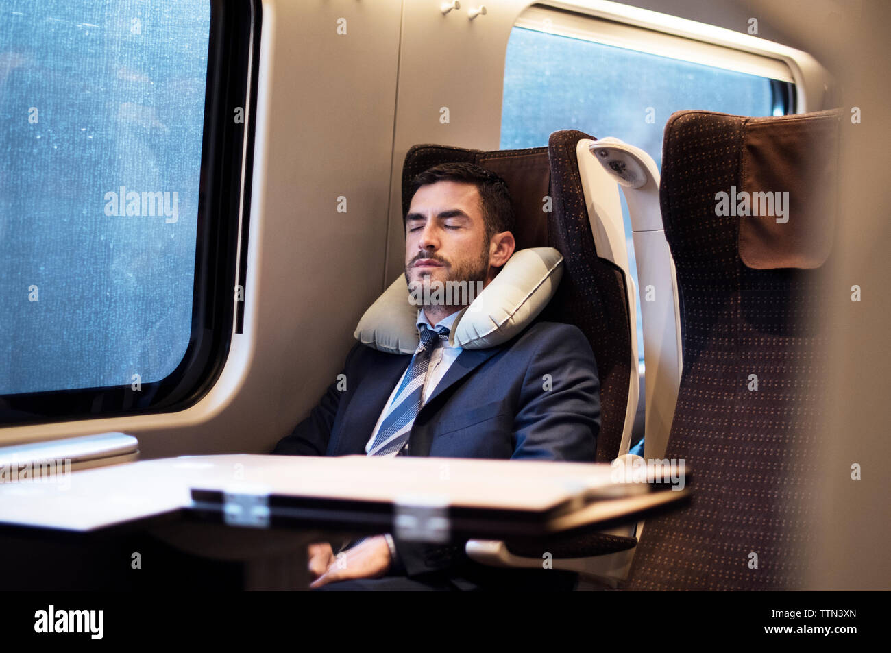 homme d'affaires dormant dans le train Banque D'Images